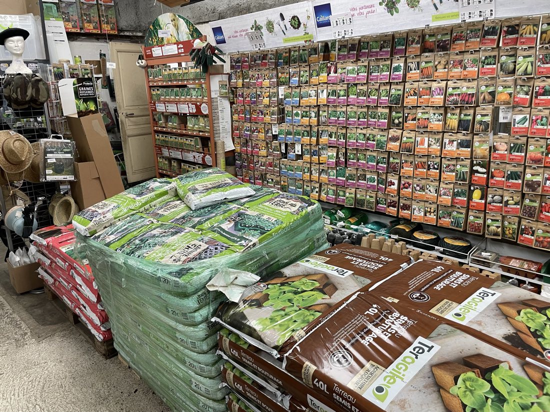Le mur de sachets de graines et les sacs de terreau